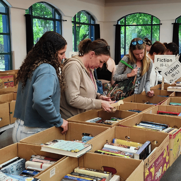 Group browsing items A group of women peruse boxes of fiction books