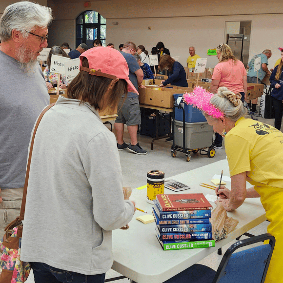 Talling total at the booksale A Friend of the Library totals the cost of a stack of books
