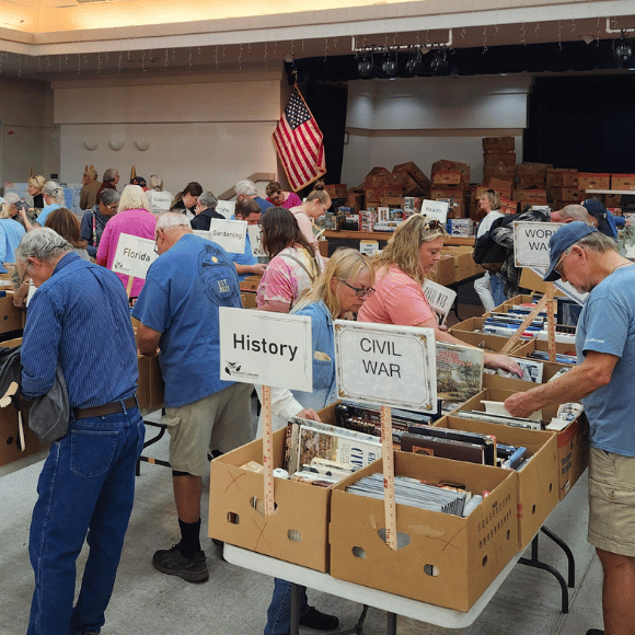 View of the booksale Crowd looking through books in boxes on rows of tables